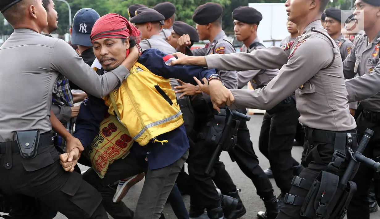 Seorang mahasiswa terlibat kericuhan dengan polisi saat unjuk rasa di depan Istana Negara, Kamis (18/5). Kericuhan terjadi karena polisi memaksa untuk membubarkan massa aksi yang dinilai tidak koperatif. (Liputan6.com/Immanuel Antonius)