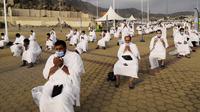 Para jemaah berdoa saat melaksanakan rangkaian ibadah haji di Padang Arafah, dekat Makkah, Arab Saudi, Kamis (30/7/2020). Hanya sekitar 1.000 jemaah yang diizinkan untuk melakukan ibadah haji tahun ini karena pandemi virus corona COVID-19. (AP Photo)