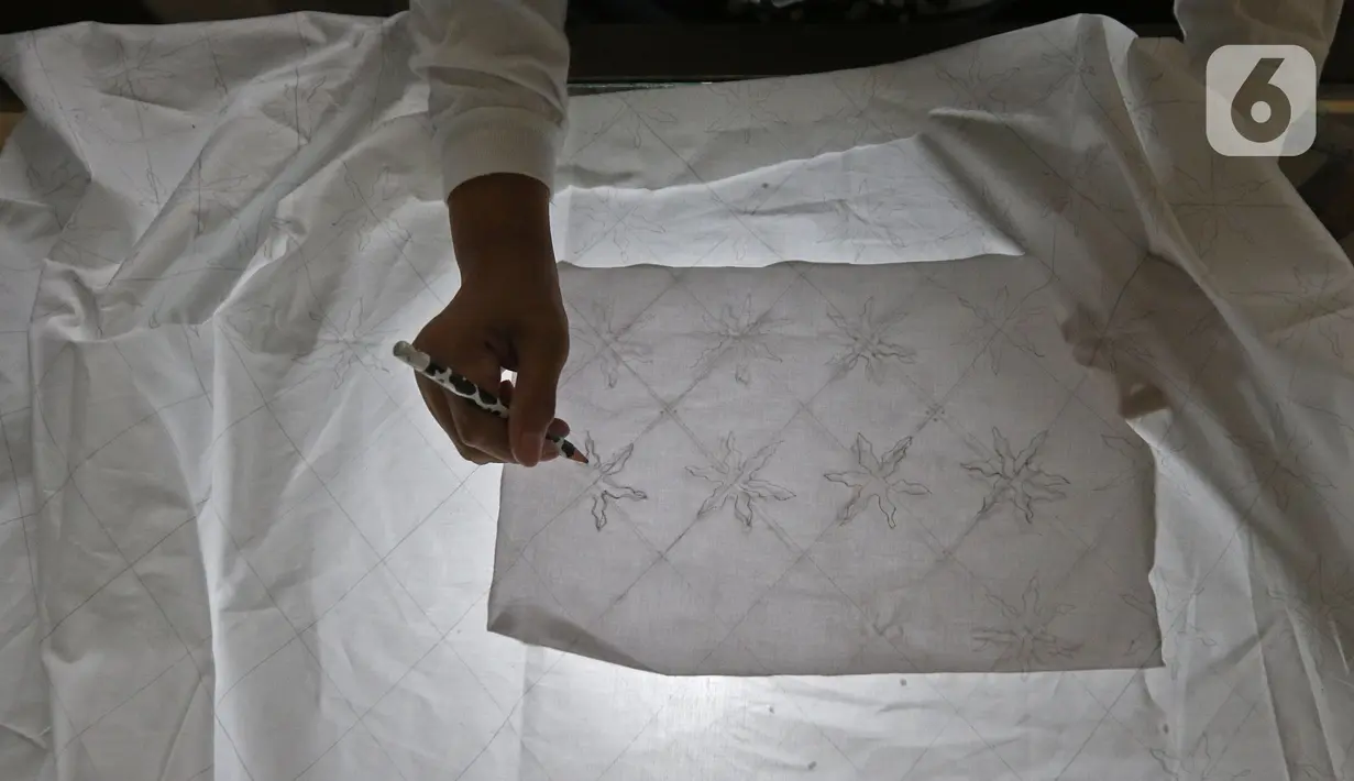 Perajin menyelesaikan salah satu tahapan produksi batik Marunda di Rusunawa Marunda, Jakarta, Selasa (14/7/2020). Batik Marunda memiliki pelanggan tetap yang kerap memesan atau secara online. (Liputan6.com/Herman Zakharia)