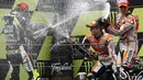 Selebrasi kemenangan tiga pembalap MotoGP di podium. Tampak, Valentino Rossi, Marc Marquez, dan Dani Pedrosa (dari kiri ke kanan) menyemprotkan sampanye di atas podium GP Katalunya, Barcelona, (15/6/2014). (REUTERS/Quique Garcia)