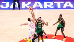Pebasket Brasil, Bruno Caboculo (kanan) berebut bola dengan pebasket Kanada, Dwight Powell saat melakukan tip off pada laga Grup L Piala Dunia FIBA 2023 di Indonesia Arena, Senayan, Jakarta, Jumat (01/09/2023). Kanada kalah dengan skor 65-69. (Bola.com/Bagaskara Lazuardi)