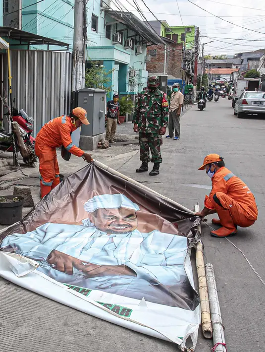 Petugas PPSU didampingi TNI dan Polri mencopot baliho Rizieq Shihab di Kawasan Kramat Pulo Dalam Senen, Jakarta, Rabu (25/11/2020). Pihak kelurahan, TNI dan Polri terus berupaya menurunkan baliho dan spanduk yang tidak berizin, termasuk salah satunya baliho Rizieq Shihab (Liputan6.com/Faizal Fanani)