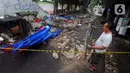 Seorang warga menyaksikan robohnya tembok SPBU yang menewaskan tiga orang di Jalan Tebet Barat Dalam Dua, Jakarta Selatan, Minggu (21/1/2024) siang. (merdeka.com/Arie Basuki)