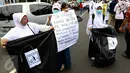 Sejumlah relawan membawa kantong plastik besar dan spanduk bertuliskan "Throw A HOAX, Here Please" di tengah aksi damai 4 November di Jakarta, Jumat (4/11). Mereka mengumpulkan sampah yang dibuang anggota ormas. (Liputan6.com/Faizal Fanani)