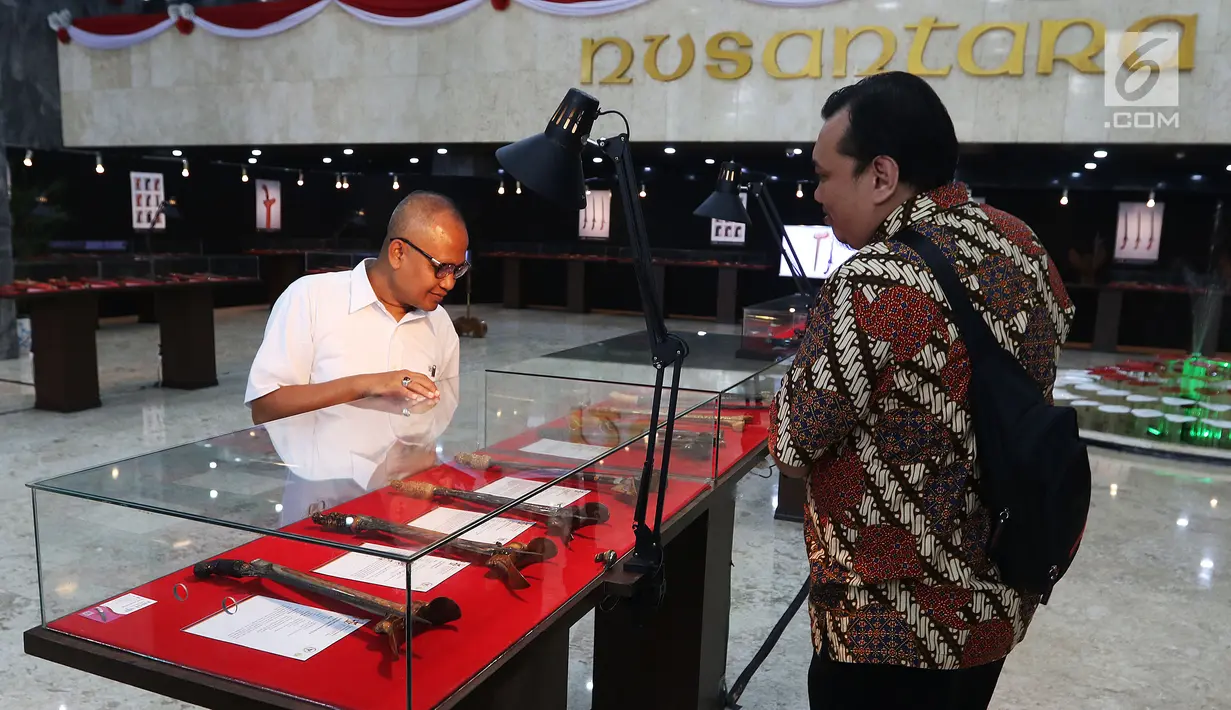 Pengunjung mengamati koleksi keris saat Pameran Keris Madura di Gedung Nusantara, Kompleks Parlemen Senayan, Jakarta, Kamis (21/3/2019). Pameran itu untuk memperkenalan kekayaan budaya keris Madura di lingkungan parlemen DPR. (Liputan6.com/Johan Tallo)