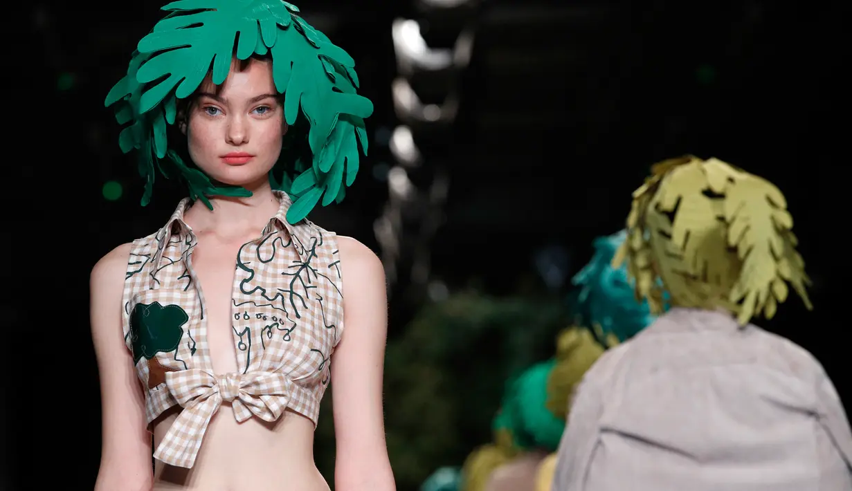 Model memperagakan koleksi Womenswear Spring/Summer 2018 untuk desainer Jepang Junko Shimada di Paris Fashion Week, Selasa (3/10). Junko menampilkan para model dengan rambut unik yang dihiasi daun. (AP Photo/Christophe Ena)