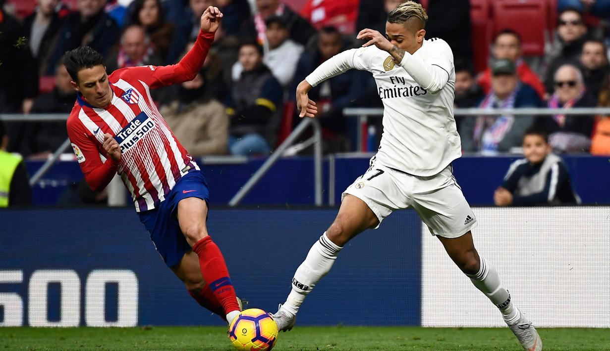 Bek Atletico Madrid, Santiago Arias berusaha merebut bola yang dibawa striker Real Madrid, Mariano selama pertandingan lanjutan La Liga Spanyol di stadion Wanda Metropolitano (9/2). Real Madrid menang 3-1 atas Atletico. (AFP Photo/Pierre-Philippe Marcou)