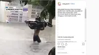 Pria ini panggul sepeda motor lewati banjir (@neng_jepret/Instagram),