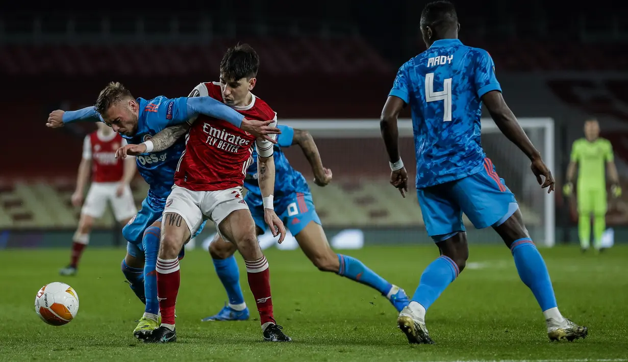 Bek Arsenal, Hector Bellerin (tengah) berebut bola dengan bek Olympiakos, Oleg Reabciuk dalam laga leg kedua babak 16 besar Liga Europa 2020/2021 di Emirates Stadium, London, Kamis (18/3/2021). Arsenal kalah 0-1 dari Olympiakos. (AP/Matt Dunham)