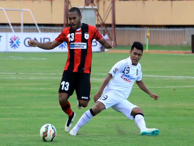 Gelandang Persipura Ian Kabes terbang setelah diterjang pemain Bali United Hendra Sandi. (Liga Indonesia)