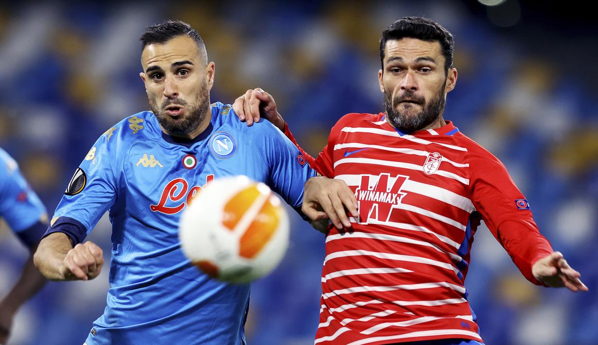 Striker Granada, Jorge Molina (kanan) berebut bola dengan bek Napoli, Nikola Maksimovic dalam laga leg kedua babak 32 Besar Liga Europa 2020/21 di Diego Armando Maradona Stadium, Kamis (25/2/2021). Granada kalah 1-2 dari Napoli. (LaPresse via AP/Alessandro Garofalo)