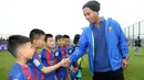Pemain sepak bola asal Brasil, Ronaldinho bersalaman dengan pemain bola cilik di China (24/2). Mantan pemain klub Spanyol, Barcelona itu menghadiri peresmian berdirinya akademi sepak bola Barcelona di China. (Handout / Mission Hills / AFP)