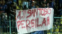 Aremania membentangkan spanduk soal Aji Santoso setelah Arema FC gagal mengalahkan Borne FC, Minggu (30/7/2017) di Stadion Kanjuruhan, Kabupaten Malang. (Bola.com/Iwan Setiawan)