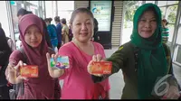 Tiga orang penumpang busway memperlihatkan e-ticket yang baru saja dibelinya seharga Rp.20.000, Jakarta, Senin (11/8/2014)(Liputan6.com/Faizal Fanani)
