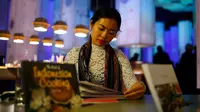 Seorang wanita membaca salah satu buku sastra asal Indonesia selama pameran Frankfurt book fair, Jerman, Selasa (13/10/2015). Pameran buku mengambil tema sastra Indonesia. (REUTERS/Ralph Orlowski) 