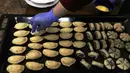 Seorang warga Irak membuat kue tradisional yang dikenal sebagai Kleicha untuk perayaan Idul Fitri di Baghdad, Irak, pada 23 Mei 2020. Kleicha, kue populer yang terbuat dari tepung dan mentega di Irak, dikreasikan dalam berbagai bentuk dengan beragam isian. (Xinhua/Khalil Dawood)