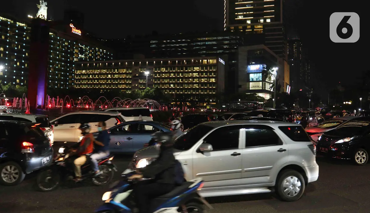 Sejumlah kendaraan melintas di kawasan Bundaran HI, Jakarta, Kamis (31/3/2022). Kawasan Bundaran HI terpantau mulai padat saat jam pulang kantor pada PPKM Level 2. (Liputan6.com/Herman Zakharia)