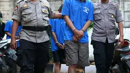 Polisi menggiring tersangka kejahatan begal spesialis handphone di Mapolsek Benda, Tangerang, Banten, Senin (19/11). Polisi menyita barang bukti handphone dan celurit. (Liputan6.com/Fery Pradolo)
