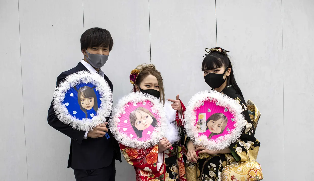 Keita Daisen, Sara Watanabe dan Honoka Watanabe berusia 20 tahun dari Jepang (kiri ke kanan) mengenakan kimono dan berpose di luar Todoroki Arena selama upacara perayaan "Coming-of-Age Day" di Kawasaki, prefektur Kanagawa (11/1/2021). (AFP/Behrouz Mehri)