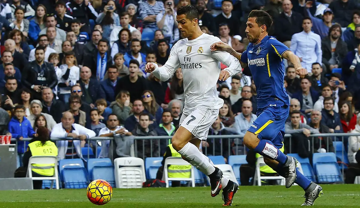 Penyerang Real Madrid, Cristiano Ronaldo, menggiring bola melewati pemain Getafe pada laga La Liga di Stadion Santiago Bernabeu, Spanyol, Sabtu (5/12/2015). (EPA/J.P. Gandul)