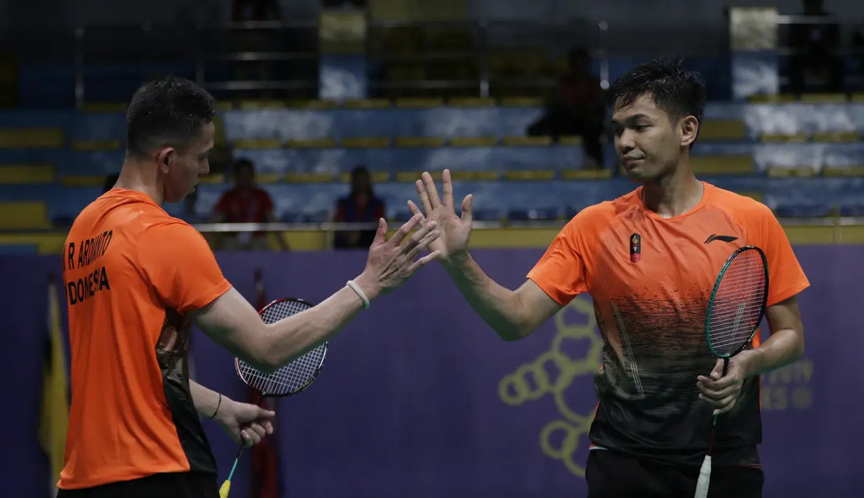 Ganda putra Indonesia, Fajar Rian / Muhammad Rian, melakukan tos saat melawan Aaron Chia / Soh Wooi Yik pada final beregu SEA Games 2019 di Multinlupa Sport Center, Rabu (4/12). Fajar / Rian kalah 17-21 dan 13-21. (Bola.com/M Iqbal Ichsan)