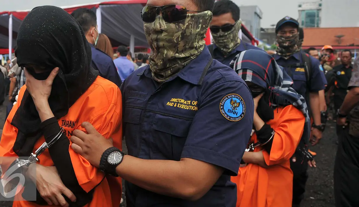 Tersangka saat dikawal petugas saat pemusnahan barang bukti narkotik jenis shabu sebanyak 120 kilogram di Jakarta, Jumat (26/2). Barang bukti narkoba didapat BNN dari hasil tangkapan sejak awal Januari 2016. (Liputan6.com/Gempur M Surya)