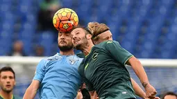 Pemain Lazio, Marco Parolo (kiri)  berebut bola dengan pemain Palermo Alberto Gilardino  pada lanjutan liga Serie A  Italia di Stadion Olimpiade, Roma, MInggu (22/11/2015). (AFP Photo/Gabriel Bouys)