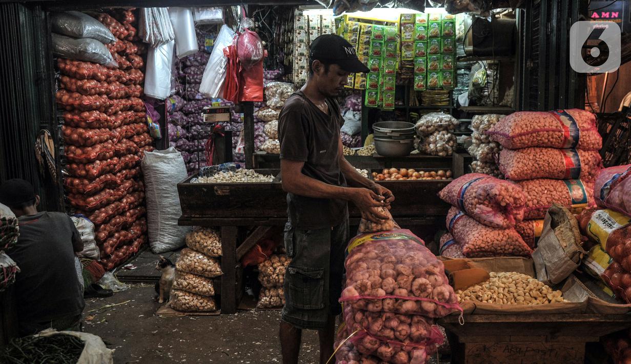 Pedagang mengemas bawang putih di Pasar Induk Kramat Jati, Jakarta Timur, Rabu (14/12/2022). Ikatan Pedagang Pasar Indonesia (Ikappi) mencatat sejumlah komoditas pangan terus mengalami kenaikan menjelang Natal dan Tahun Baru (Nataru). (merdeka.com/Iqbal S. Nugroho)
