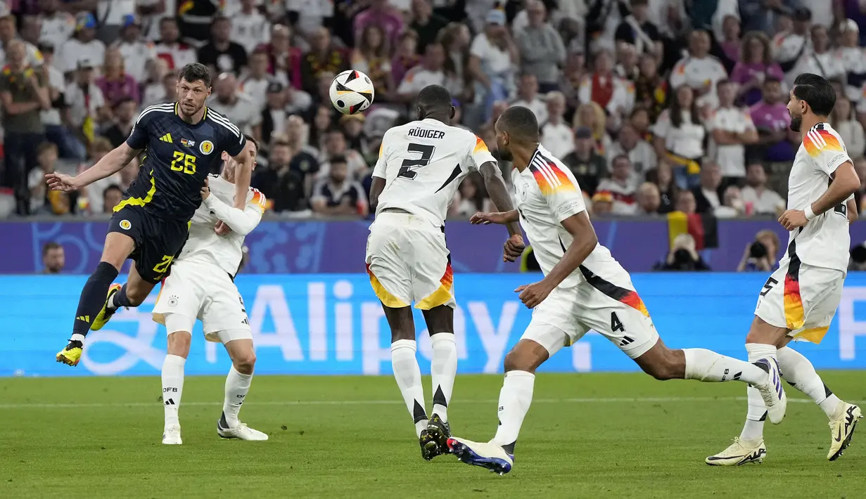 Bek Timnas Jerman, Antonio Rudiger menjadi pembuka gol bunuh diri di ajang Euro 2024. Saat laga pembuka Euro 2024 antara Timnas Jerman kontra Skotlandia di Grup A (15/6/2024) ia membuat gol bunuh diri pada menit ke-87 saat Tim Panzer sudah unggul empat gol. Gol berawal dari tendangan bebas dari luar kotak penalti yang berakibat kemelut di depan gawang Manuel Neuer, bola pun secara reflek mengenai kepala Antonio Rudiger yang meluncur deras ke dalam gawang. Skor akhir Timnas Jerman menang 5-1. (AP Photo/Matthias Schrader)