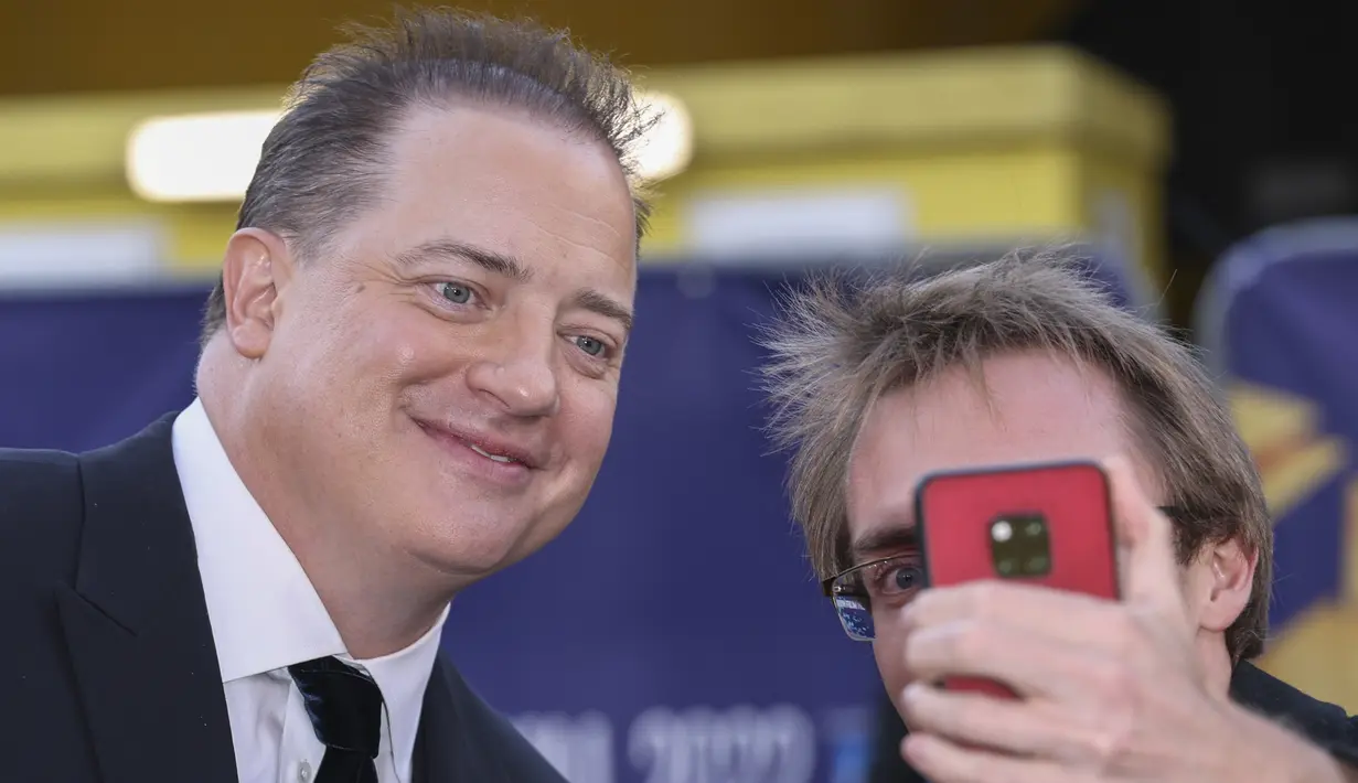 Brendan Fraser berselfie dengan penggemar saat tiba untuk pemutaran perdana film 'The Whale' selama Festival Film London 2022 di London, Selasa, 11 Oktober 2022. Sejak pemutaran perdana di Venice Film Festival bulan lalu, The Whale telah mendapatkan sambutan hangat dari para kritikus, dan telah memulai kembalinya Brendan. (Photo by Vianney Le Caer/Invision/AP)