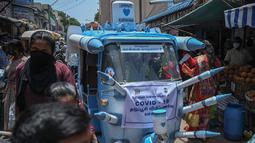 Sebuah bajaj yang dihias dengan replika jarum suntik besar melintasi jalanan di Chennai, India, Sabtu (3/6/2021). Seorang seniman di Chennai menghias bajaj tersebut untuk meningkatkan kesadaran orang-orang tentang pentingnya vaksinasi Covid-19 di tengah sejumlah temuan varian baru. (Arun SANKAR/AFP)