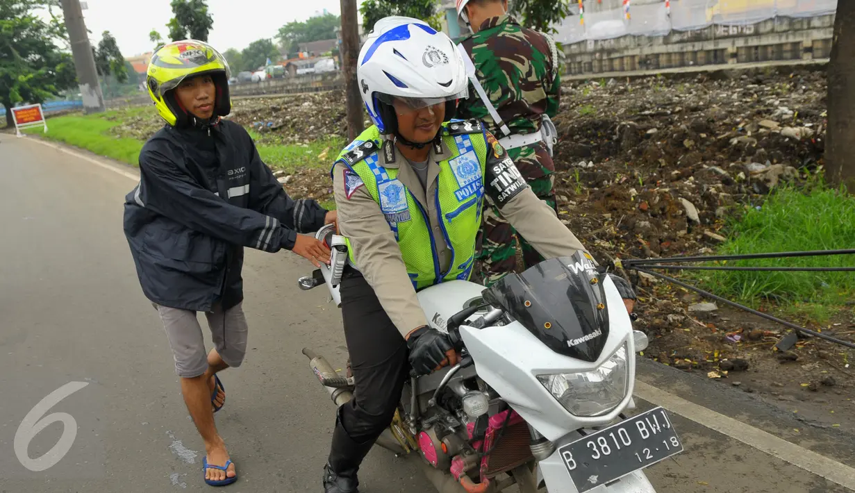 Petugas membawa motor milik seorang pengendara saat Operasi Gaktib Garnisun Tetap 1 di kawasan Pesing, Jakarta,  Kamis, (11/2/2016). Razia dilakukan untuk menertibkan aksesoris berlambangkan TNI dan Polri. (Liputan6.com/Faisal R Syam)