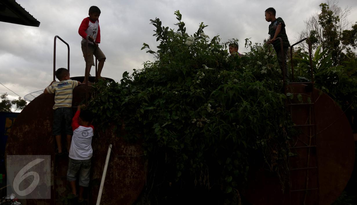 Sejumlah anak terlihat bermain di atas tangki di pengungsian Sinabung, Desa Batu Karang, Medan, Sabtu (4/7/2015). Sebanyak 1254 jiwa dari desa Gursinayan sudah mengungsi selama 1 bulan. (Liputan6.com/JohanTallo)