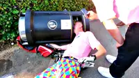 Seorang pemain golf kesulitan melepaskan kepalanya yang terjebak dalam keranjang sampah karena ia sedang mabuk.