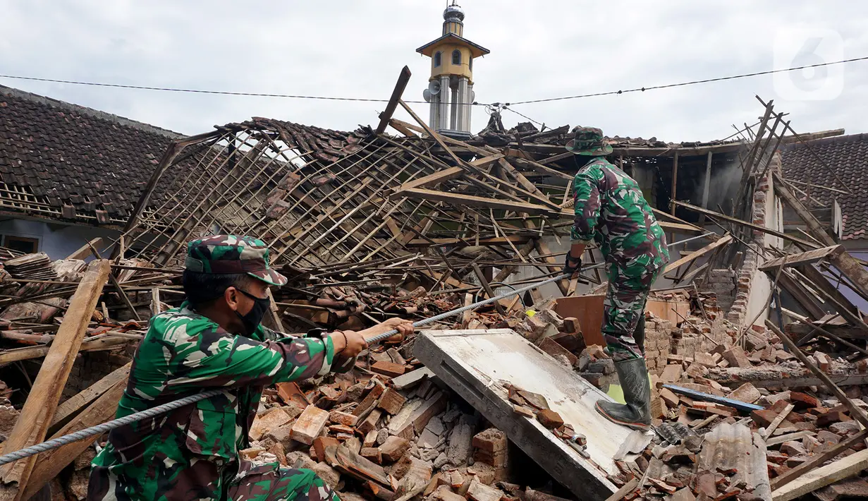 Prajurit TNI merobohkan rumah yang mengalami kerusakan berat akibat gempa di Dusun Krajan, Majangtengah, Kabupaten Malang, Minggu (11/4/2021). Sejumlah rumah yang rusak berat terpaksa dirobohkan untuk meminimalisir adanya korban jika terjadi gempa susulan. (merdeka.com/Nanda F. Ibrahim)