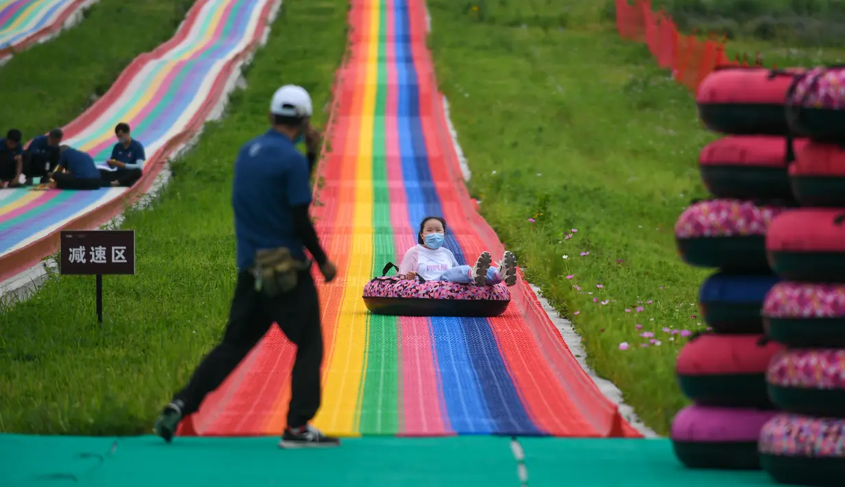 Seorang anak bermain seluncuran di sebuah kawasan resor di Kota Jilin, Provinsi Jilin, China pada 19 Juli 2020. Arena ski di kawasan resor itu diubah menjadi ladang bunga, seluncuran, dan beragam proyek pariwisata rekreasi lainnya guna menarik wisatawan pada musim panas. (Xinhua/Yan Linyun)