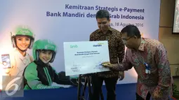 Direktur Digital Banking and Technology Bank Mandiri Rico Usthavia Frans (kanan) menandatangi perjanjian kerja sama antara Bank Mandiri dengan Grab Indonesia di Plaza Bank Mandiri, Jakarta, Kamis (18/8). (Liputan6.com/Angga Yuniar)