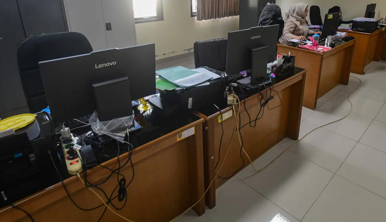 Kebijakan ini menjadi bagian dari strategi efisiensi energi di tengah dinamika global, termasuk konflik di Timur Tengah. Tampak dalam foto, pegawai bekerja di depan komputer dengan beberapa meja kursi yang kosong saat penerapan Work From Home (WFH) bagi Aparatur Sipil Negara (ASN) di kantor Kecamatan Limo, Depok, Jawa Barat, Jumat (10/4/2026). (merdeka.com/Arie Basuki)