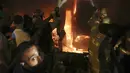 Petugas pemadam kebakaran memadamkan api di sebuah gedung setelah tangki bahan bakar meledak di lingkungan Tariq al-Jdide di Beirut (9/10/2020) waktu setempat.  Ledakan terjadi usai sebuah tangki BBM terbakar di distrik Tariq al-Jdide, Sabtu (10/10/2020). (AP Photo/Bilal Hussein)