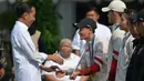 Presiden Joko Widodo menyalami peraih medali emas Indonesia di cabang olahraga panjat tebing Olimpiade Paris 2024, Veddriq Leonardo saat upacara penerimaan yang dilakukan di Istana Merdeka, Jakarta, pada Kamis 15 Agustus 2024. (BAY ISMOYO/AFP)