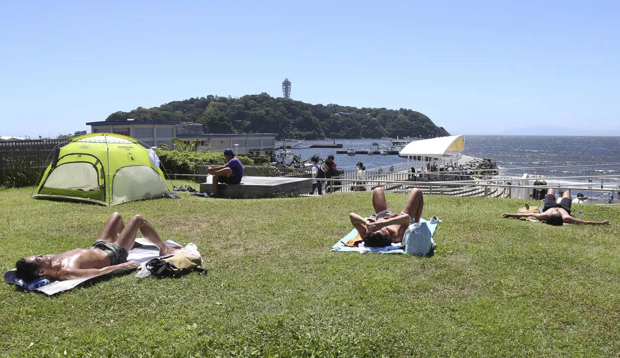 Para sunbathers beristirahat di Pantai Shonan di bawah terik musim panas di Fujisawa dekat Tokyo, Selasa, (11/8/2020). (AP / Koji Sasahara)