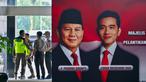 Anggota keamanan gedung parlemen Republik Indonesia berkoordinasi di dekat foto-foto pelantikan presiden dan wakil presiden terpilih 2024-2029, Prabowo Subianto-Gibran Rakabuming Raka, Jakarta pada 18 Oktober 2024. (BAY ISMOYO/AFP)