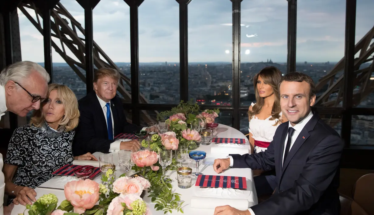 Presiden AS Donald Trump dan Melania Trump duduk bersama Presiden Prancis Emmanuel Macron dan Brigitte Macron dalam jamuan makan malam di Menara Eifel, Paris, Kamis (13/7). Kunjungan Trump ke Paris, merupakan undangan Macron. (AP Photo/Carolyn Kaster)