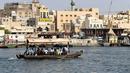 Orang-orang naik perahu di atas kapal kayu tradisional di dekat Deira Souk di Teluk Emirat Dubai (30/9/2020). (AFP/Karim Sahib)
