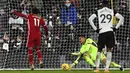 Pemain Liverpool Mohamed Salah (kiri) mencetak gol dari titik penalti ke ke gawang Fulham pada pertandingan Liga Premier Inggris di Stadion Craven Cottage, London, Minggu (13/12/2020). Liverpool dan Fulham bermain imbang 1-1. (Neil Hall/Pool via AP)
