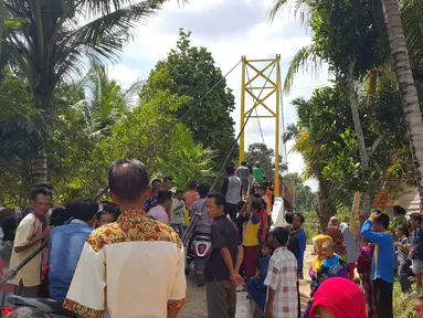 Warga saat menyaksikan peresmian Jembatan Asa di Desa Pintas Tuo, Kecamatan Muara Tabir, Jambi, (7/8). Jembatan itu sangat berarti bagi warga, karena menjadi penghubung akses antardesa yang selama ini terputus. (Liputan6.com/dok SCTV)