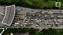 <p>Foto aerial kendaraan terjebak macet di Pintu Tol Cikupa, Tangerang, Banten, Kamis (28/4/2022). Memasuki H-4 Hari Raya Idulfitri 1443 H atau Lebaran 2022, kendaraan pemudik dengan menggunakan kendaraan pribadi mengular di pintu tol Cikupa arah Merak. Kemacetan terjadi kurang lebih hingga dua km meter. (Liputan6.com/Angga Yuniar)</p>