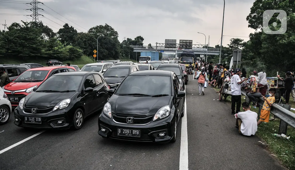Wisatawan keluar dari mobil saat terjebak penutupan jalur arah Puncak di Tol Jagorawi, Pandansari, Bogor, Jawa Barat, Minggu (19/9/2021). Penutupan jalur sejak siang tadi menyebabkan ribuan kendaraan arah Puncak terjebak kemacetan hingga beberapa kilometer. (merdeka.com/Iqbal S. Nugroho)