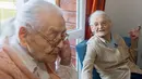 Paulette Olivier (kanan) dan Simone Thiot berbincang saat berada di Ephad "Les Bois Blancs", Prancis (13/2). Paulette dan Simone perempuan berusia 104 tahun ini diyakini sebagai wanita kembar tertua di dunia. (AFP PHOTO/GUILLAUME souvent)