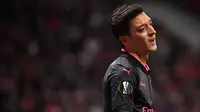Reaksi gelandang Arsenal, Mesut Ozil selama laga leg kedua semifinal Liga Europa melawan Atletico Madrid di Wanda Metropolitano, Kamis (3/5). Arsenal tersingkir dari Liga Europa setelah kalah 0-1 atas Atletico Madrid. (AFP/PIERRE-PHILIPPE MARCOU)